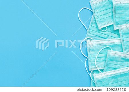 Surgical face mask on blue background protection against COVID-19 coronavirus. Healthcare and medical concept 109288258