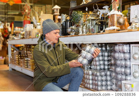 Man buying christmas balls on sale in store 109288836