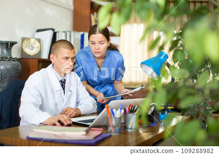 Young colleagues-doctors discuss the appointment of treatment, sitting at the computer in the office 109288982