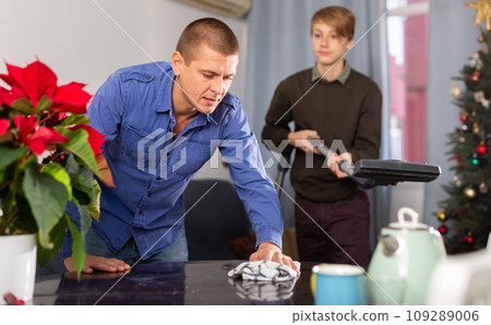 Father and son cleaning room together before christmas Father and son cleaning room together before christmas 109289006