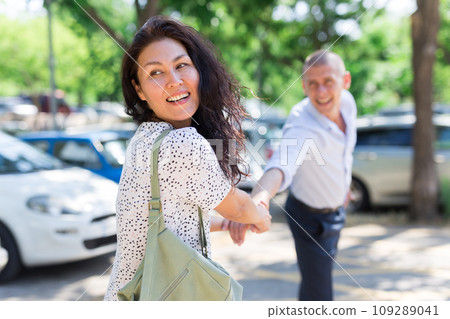 Woman pulling her husband's hand Woman pulling her husband's hand 109289041