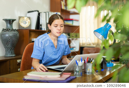Woman doctor sitting at workplace with computer in office Woman doctor sitting at workplace with computer in office 109289046