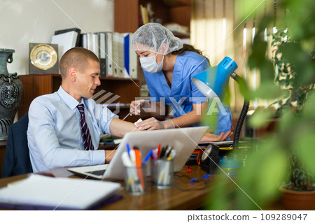 Young nurse in a protective mask, vaccinates a man Young nurse in a protective mask, vaccinates a man 109289047