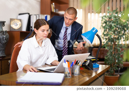 Confident businessman in the office with a girl colleague, discusses important topical issues 109289088