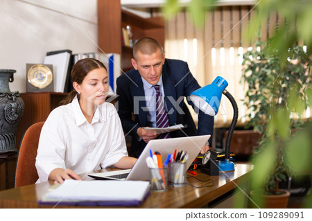 Man manager helping to woman during working at lapto 109289091