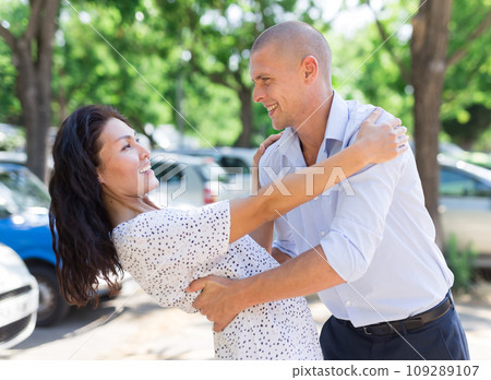Woman and man hugging in parking lot Woman and man hugging in parking lot 109289107