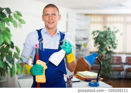 Professional cleaner in uniform ready for cleaning in office 109289111