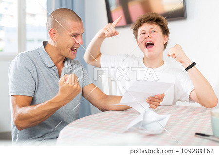 Father congratulates his son after reading letter from college 109289162