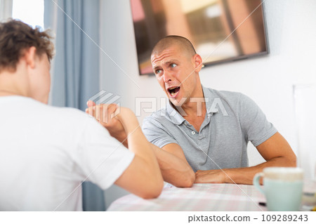 Father and son competing in arm wrestling Father and son competing in arm wrestling 109289243
