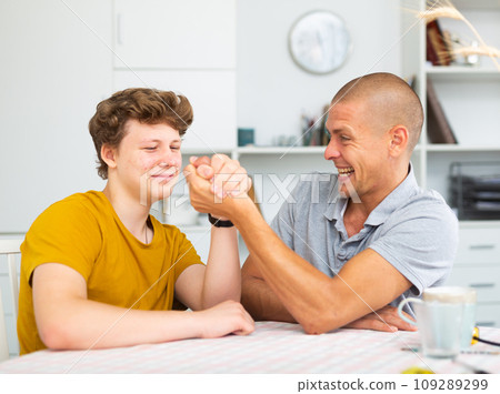 Father and his son doing arm wrestling Father and his son doing arm wrestling 109289299