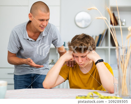 Teenager feeling upset and his father comforting him Teenager feeling upset and his father comforting him 109289305