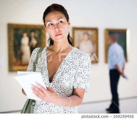Woman standing in picture gallery 109289498