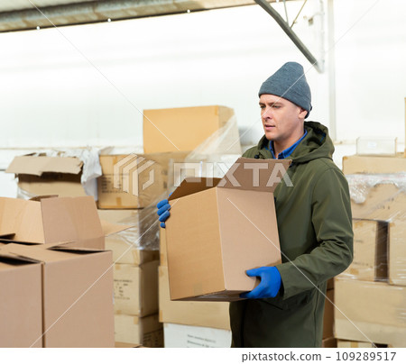 Man worker carrying cardboard box 109289517