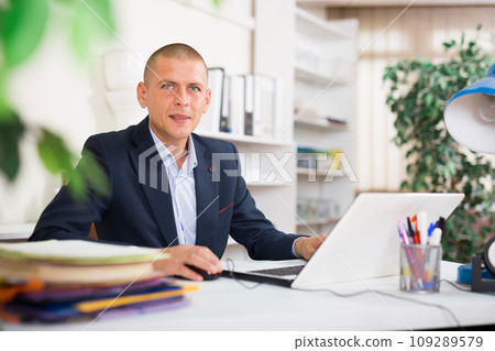 Office employee focused on working with laptop and papers 109289579