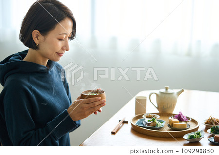 A woman holding warm miso soup in her hand A woman holding warm miso soup in her hand 109290830