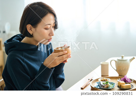 一個女人手裡拿著溫暖的味噌湯 一個女人手裡拿著溫暖的味噌湯 109290831