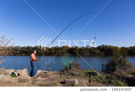 A man enjoying fishing in the river A man enjoying fishing in the river 109291007
