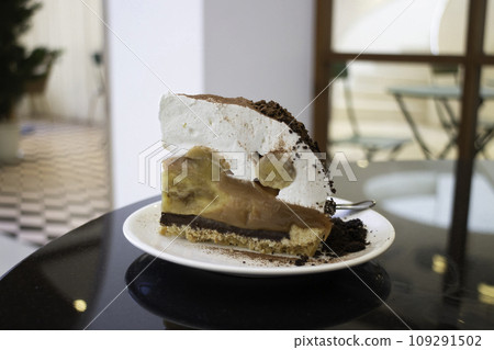 Banoffee cake with bananas and whipped cream in cafe restaurant 109291502