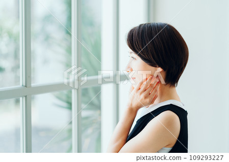 A middle-aged woman feels the moisturization of her skin. 109293227