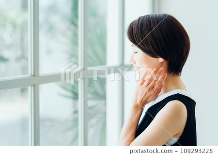 A middle-aged woman feels the moisturization of her skin. 109293228