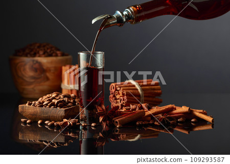 Coffee liquor is poured from a bottle into a glass. 109293587