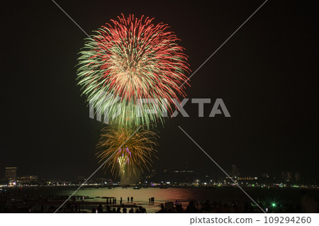 Colorful fireworks celebration with people and the city night light background at the seaside. 109294260