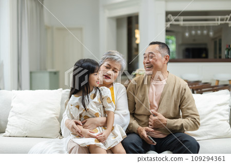 Happy Family Grandfather Grandmother and Granddaughter having fun living room at home.  109294361