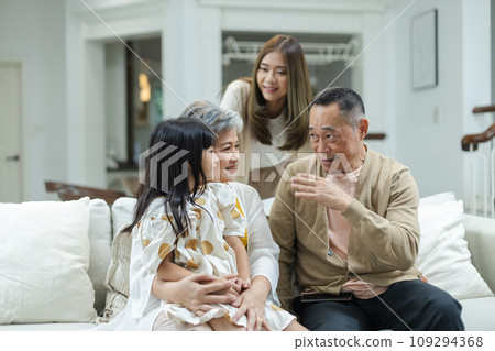 Happy Family Grandfather Grandmother and Granddaughter having fun living room at home.  109294368