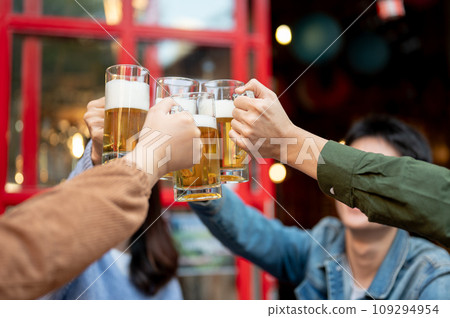 Group of cheerful young Asian friends are cheering and enjoying beer at a restaurant or bar together 109294954