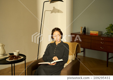 A woman relaxing on a sofa at sunset 109295431