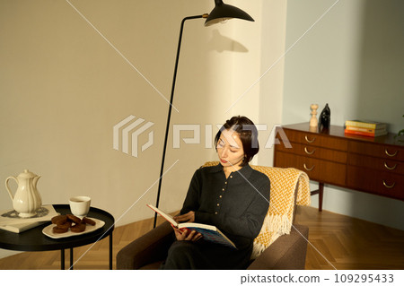 A woman relaxing on a sofa at sunset A woman relaxing on a sofa at sunset 109295433
