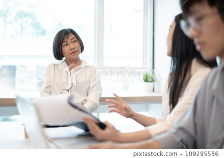 A professional senior Asian female boss is in the meeting with her team. A professional senior Asian female boss is in the meeting with her team. 109295556