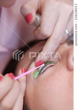 Lamination of eyelashes. Coloring and curling of eyelashes. Eyelash care procedures in beauty salon.Concept of beauty. Vertical photo. Lamination of eyelashes. Coloring and curling of eyelashes. Eyelash care procedures in beauty salon.Concept of beauty. Vertical photo. 109296017