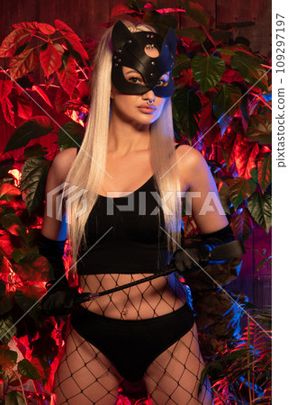 Sexy woman in cat mask. Lady with a leather whip. BDSM toys for role-playing sexual games with domination and submission 109297197