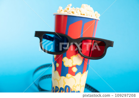 Movie clapper, pop corn, 3D glasses and film reel on blue background. Collage design 109297208