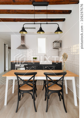 Dining table under vintage chandelier in studio apartment Dining table under vintage chandelier in studio apartment 109297676