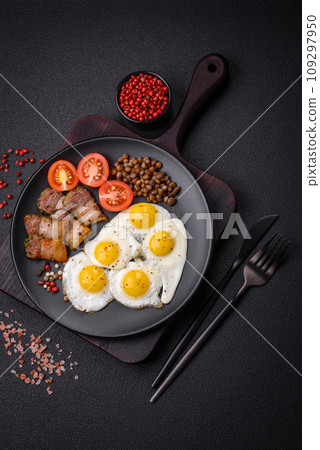 Delicious nutritious breakfast of fried quail eggs, bacon, legumes and cherry tomatoes Delicious nutritious breakfast of fried quail eggs, bacon, legumes and cherry tomatoes 109297950