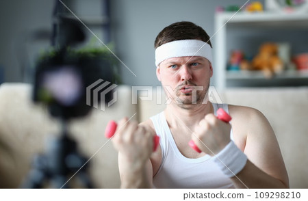 Athletic man doing physical exercises with dumbbells on camera 109298210