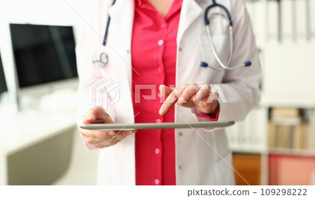 Female doctor is holding modern tablet and using remote telemedicine application 109298222