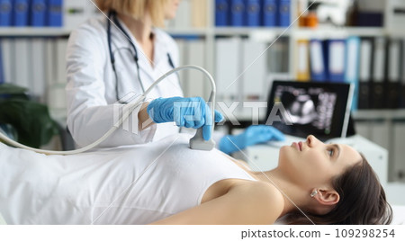 Doctor holds ultrasound probe on chest of patient in clinic closeup 109298254