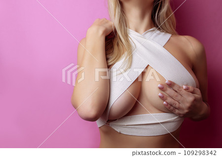 sexy woman with bandaged breasts with marks after plastic surgery operation, close-up. Cosmetology clinic, beauty, correction, cosmetic surgery, breast augmentation, wellness concept 109298342