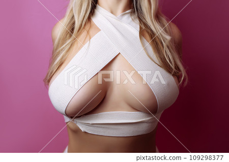 sexy woman with bandaged breasts with marks after plastic surgery operation, close-up. Cosmetology clinic, beauty, correction, cosmetic surgery, breast augmentation, wellness concept 109298377