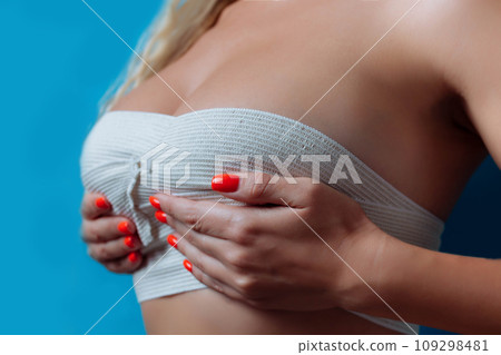 close up picture of big boobs in bandage after surgery, sexual sizebandage breast enlargement. 109298481