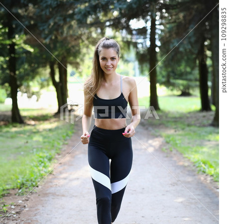 Running woman runs in park on beautiful summer day 109298835