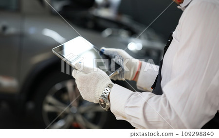 Male master locksmith holds tablet and performs car diagnostics Male master locksmith holds tablet and performs car diagnostics 109298840