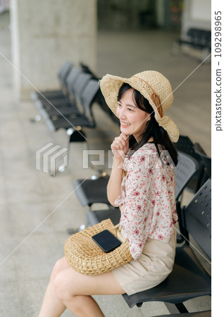 young asian woman traveler with weaving basket waiting for train in train station. Journey trip lifestyle, world travel explorer or Asia summer tourism concept. 109298965