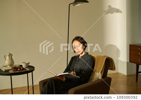 Woman relaxing on the sofa at sunset 109300392