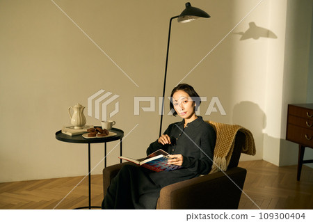 Woman relaxing on the sofa at sunset Woman relaxing on the sofa at sunset 109300404