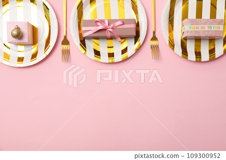 Gift boxes on plates on pink background, space for text Gift boxes on plates on pink background, space for text 109300952
