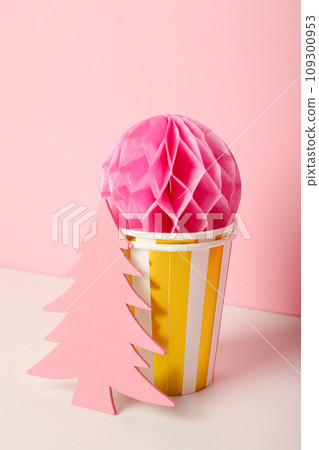 Paper cups, ball and Christmas tree on pink background Paper cups, ball and Christmas tree on pink background 109300953